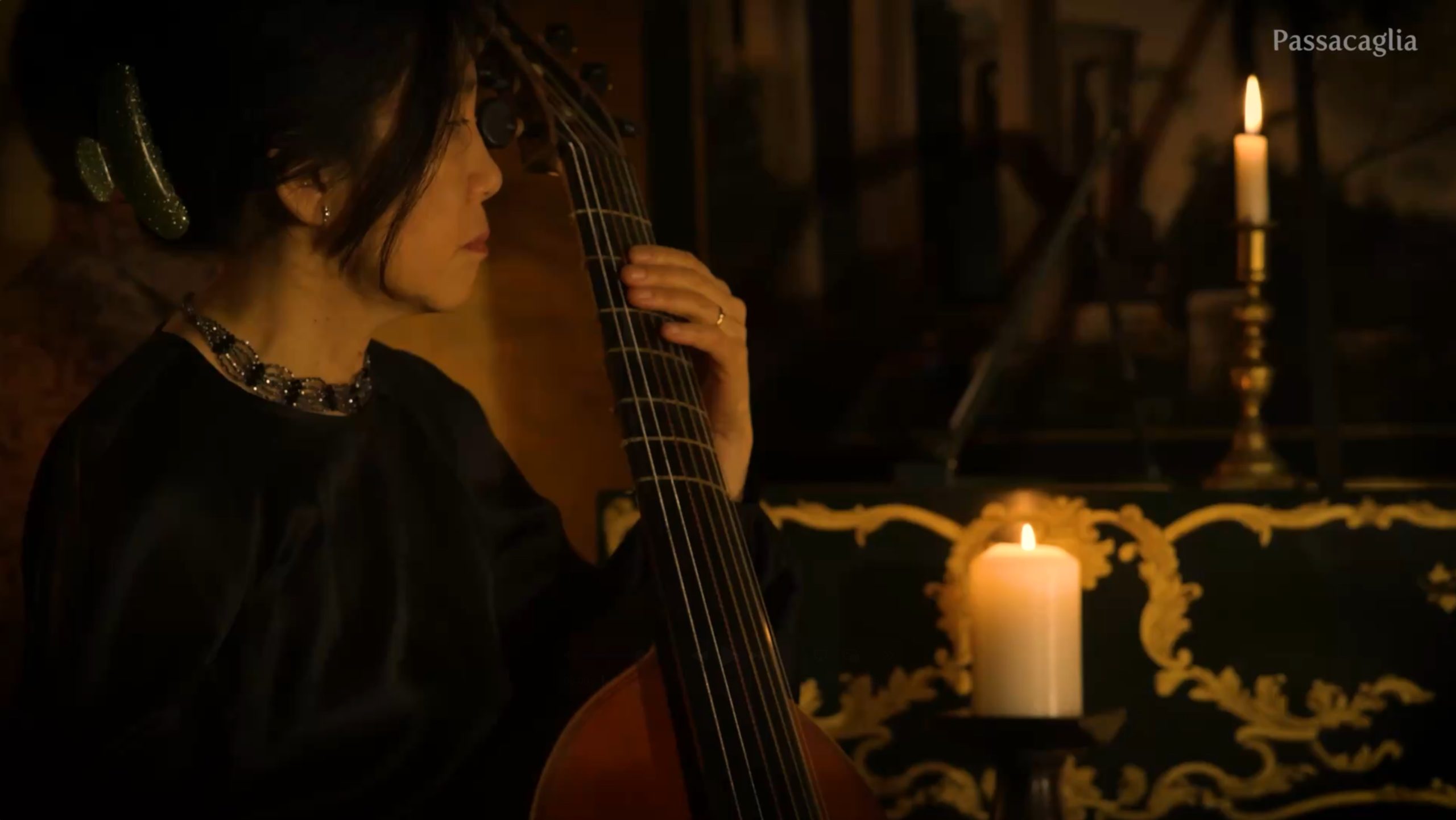 viol player in historical interior with candles